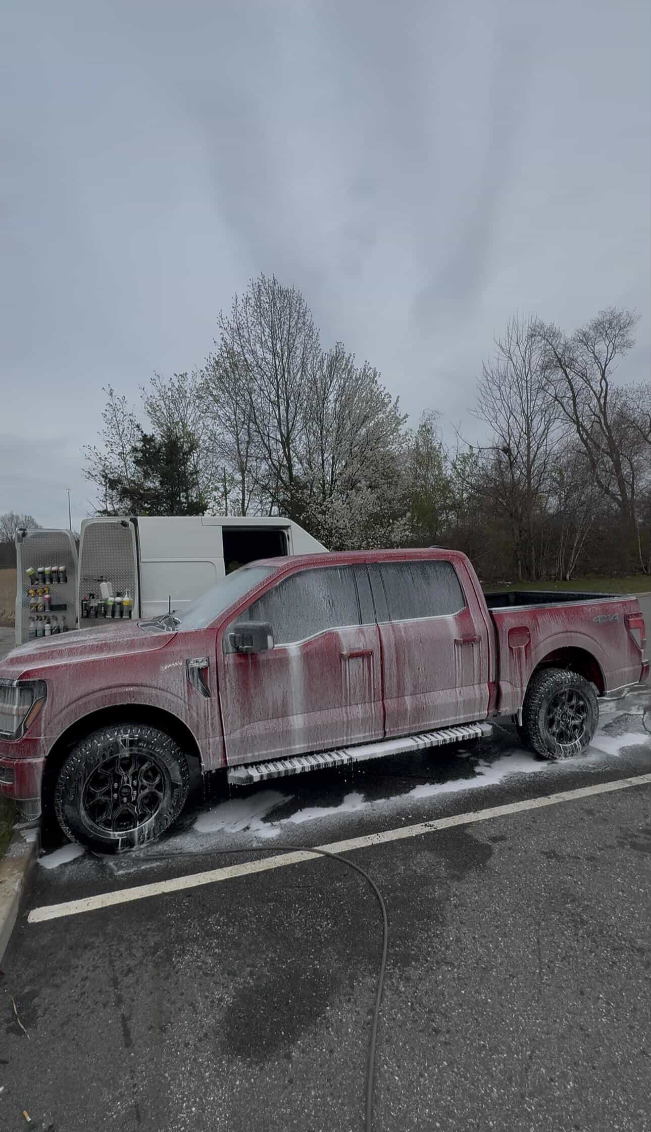 Red Ford F-150 during exterior foam wash